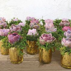 several gold vases filled with pink and purple flowers