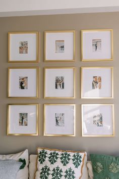 a living room filled with lots of framed pictures on the wall above a white couch