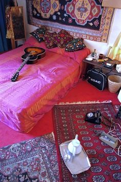 a bed room with a guitar and rugs on the floor