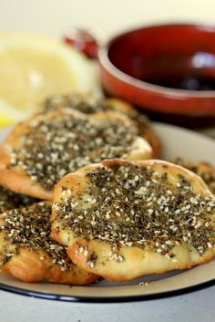 small bagels with sesame seeds on a plate next to a bowl of lemons