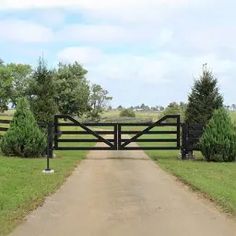 an open gate leading to a dirt road