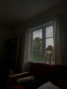 a living room filled with furniture and a lamp on top of a window sill