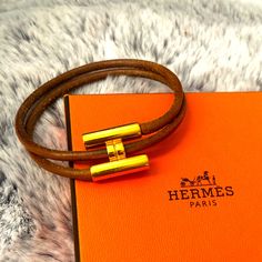 Preowned Authentic Hermes Leather Bracelet With H Metal Piece Logo Condition: Leather Piece Has Scratches, Rubbing, Black Tarnish Spot. No Tears Or Cuts. Metal Piece Has Scratches And Rubbing And Tarnish. Overall In Good Condition With No Major Issue. Will Come With Box Hermes Leather Bracelet, Hermes Leather, Hermes Jewelry, Hermes Paris, Leather Pieces, Brown Gold, Womens Jewelry Bracelets, Leather Bracelet, Overalls