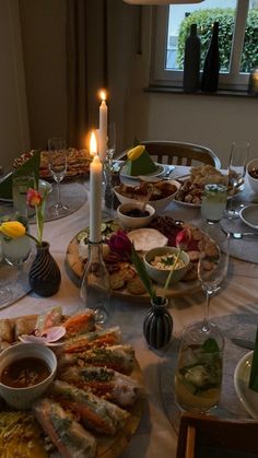 a table is set with food and candles for an elegant dinner or brunch