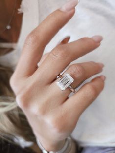 a close up of a person's hand with a ring on their finger and a baguette in the other hand