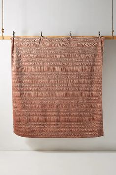 a pink blanket hanging from a wooden rack