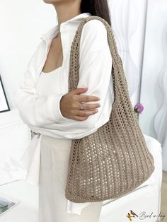 a woman is holding a crocheted bag in her hands