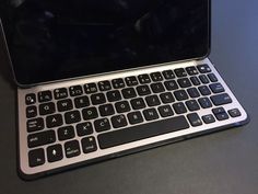 an open laptop computer sitting on top of a black table next to a mouse and keyboard