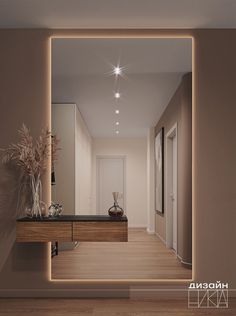 an empty hallway with a mirror and vases on the table in front of it