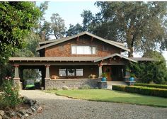 a brown house sitting on top of a lush green field