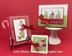 two christmas cards with candy canes on the table and one card has an elf's hat