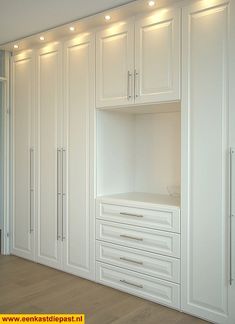 an empty white closet with drawers and lights on the wall above it's doors