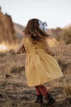 Pips and Poppy 'Harper Pinafore' in Mustard - the perfect autumn pinafore. $38 · Classic pinafore style with a modern flair. Perfect for playground adventures and days at the park. Available in sizes 2T-5T. 100% cotton #pinafore #girlsdresses #littlegirlsfashion #stylishchildhood Spring Cotton Pinafore Dress For Playdate, Summer Casual School Pinafore Dress, Casual Summer Pinafore Dress For School, Casual Summer School Pinafore Dress, Cute Spring Pinafore Dress For Playdate, Cute Sleeveless Cotton Pinafore Dress, Cute Cotton Sleeveless Pinafore Dress, Summer Cotton Ruffled Pinafore Dress, Summer Cotton Ruffle Pinafore Dress