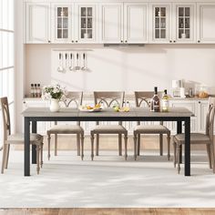 a dining room table with chairs and bottles on the counter top in front of white cabinets