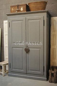 an armoire with two doors and baskets on top