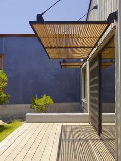 an outdoor area with wooden flooring and pergolated roof