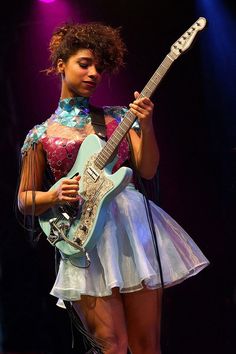 a woman with an electric guitar on stage