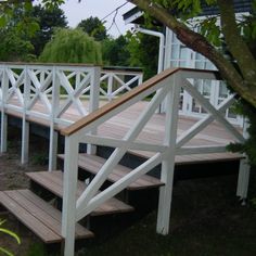 a white wooden deck with steps leading up to the top and bottom part of it