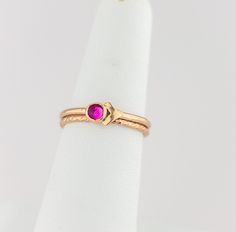 These luxurious cubic zirconia stacking rings are meticulously crafted by hand and feature a striking fuchsia cubic zirconia stone set in a gold-filled bezel. The vibrant dark pink hue of the dark pink cubic zirconia stone complements the bright gold bands, creating a regal and timeless color combination that exudes elegance and beauty. The gold filled arrow accent adds a modern twist on these timeless treasures. Whether for everyday wear or a special occasion, these gold filled stacking rings a Pink Ruby Stackable Jewelry, Pink Stackable Birthstone Promise Ring, Gold Stackable Rings With Ruby Bezel Setting, Pink 14k Gold Stackable Ruby Ring, Pink 14k Gold Stackable Rings For Anniversary, Stackable Pink Ruby Ring In 14k Gold, Gold Stackable Ruby Ring, Gold Stackable Rings With Pink Sapphire, Pink Ruby Birthstone Ring In 14k Gold