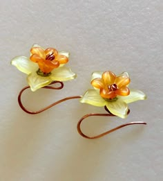 "Darling lightweight yellow daffodils with orange centers dangle on handmade natural copper hooks of 20 gauge German copper wire. Delicate lucite daffodil flower measures 20 mm wide and is embellished with bright orange lucite center flower and tiny lacey copper bead caps. Total length is 1\". Darling springtime accessory!" Orange Daffodils, Lucite Flowers, Bright Copper, Daffodil Flower, Yellow Daffodils, Flowers Handmade, Dope Jewelry, Earrings Flower, Funky Jewelry