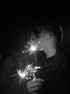 two people kissing while holding sparklers in their hands