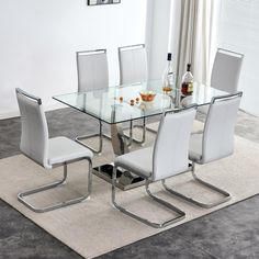 a glass table with white chairs around it