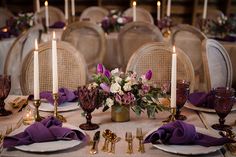 the table is set with purple napkins and place settings for two people to sit at