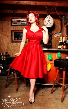 a woman in a red dress posing for the camera