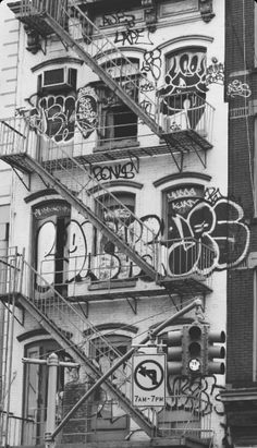 a black and white photo of a building with lots of graffiti on the side of it