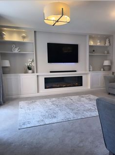 a living room filled with furniture and a flat screen tv mounted on the wall above a fireplace