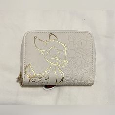 a white wallet with gold foiling on the front and side, featuring an image of a mouse