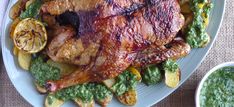 a large piece of meat sitting on top of a white plate next to some veggies