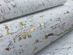 closeup of white and gold paint on the side of a piece of wood that has been cut in half