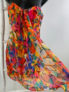 "Fun colorful light and airy Oscar de la Renta vintage 80s abstract floral silk chiffon print cocktail dress. Layers of sheer chiffon. Top layer in the floral print has a tight side flowy pleat over layer. Lined in two layers of sheer coral silk chiffon. Boned and lined bustier with left side zipper that is covered with hidden tiny snap buttons. Empire under bust grosgrain tape that secures at left side. All these exquisite details are for support and show true craftsmanship. Marked size 4 - see Flowy Multicolor Silk Chiffon Dress, Multicolor Silk Chiffon Party Dresses, Multicolor Silk Chiffon Dress For Spring, Multicolor Fitted Silk Chiffon Dress, Fitted Multicolor Silk Chiffon Dress, Vintage Silk Chiffon Summer Dress, Vintage Silk Chiffon Dress For Summer, Retro Sheer Summer Dress, Dress Layers