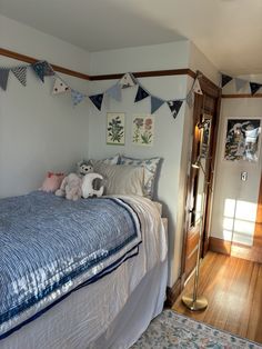 a bedroom with a bed, pillows and bunting flags on the wall above it