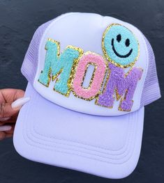 Celebrate mom with this custom trucker hat featuring a cheerful smiley patch! Perfect for everyday wear, this personalized cap adds a fun and trendy touch to any outfit. Whether for a casual outing or a special gift, this unique mom hat is both stylish and practical. Show your love and appreciation with this adorable and custom trucker hat! High quality patches with adjustable SnapBack hat.   💞SHIPPING  We have a 3-5 (business days) processing/shipping turnaround time.  Most orders ship out within 1-2 business days. Adjustable Cotton Hat With Smiley Face, Fun Adjustable Baseball Cap With Embroidered Patch, Customizable Funny Trucker Hat, Funny Customizable Trucker Hat, Fun Cotton Baseball Cap With Letter Print, Fun Trucker Hat With Letter Print, Personalized Casual Trucker Hat For Summer, Novelty Customizable Trucker Hat, Spring Letter Print Trucker Hat With Curved Visor