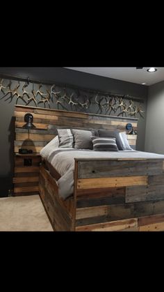 a bed made out of wooden pallets in a room with gray walls and carpet