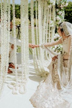 a woman in a wedding dress standing next to a man with a veil on his head