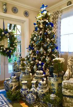 a christmas tree is surrounded by blue and white vases