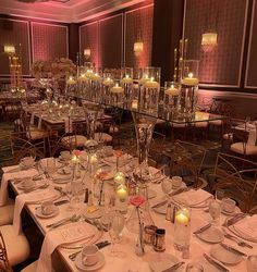 the tables are set with candles and place settings for an elegant dinner or banquet event