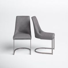 two gray chairs sitting next to each other on a white surface with one chair facing the other