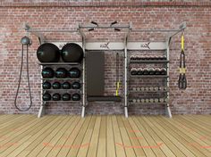 an exercise room with equipment on the wall and hard wood flooring next to it