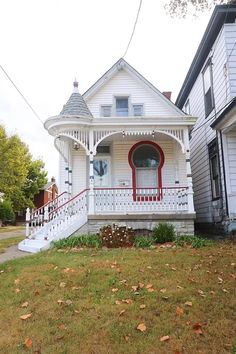 a white house with red trim and a porch