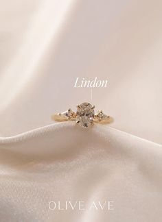 an engagement ring with three stones on it and the words lindon above it in white