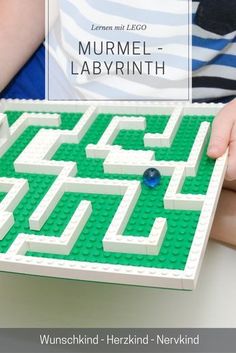 a child is holding a lego maze in front of an advertisement for the book, murmel - labrinth