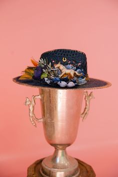 Add a playful and quirky touch to your outfit with the KENTUCKY MULE SUN HAT. This navy hat features gold accents and a unique blue flower and feather combo, with a gold horse design and horseshoe pin adding a touch of whimsy. Perfect for a day at the Derby or just soaking up the sun! This hat is ONE OF A KIND, created by our owner Stephanie. To receive item quicker, expedited shipping is available at checkout. Kentucky Derby Toquilla Straw Hat For Western-themed Events, Derby Hat Diy, Gold Wide-brim Straw Hat For Kentucky Derby, Kentucky Derby Sun Hat For Western-themed Events, Flat Crown Hats For Kentucky Derby And Western-themed Events, Kentucky Mule, Western High-crown Fedora For Kentucky Derby, Navy Hat, Navy Hats