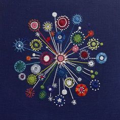 an embroidered piece of art with many different colors and shapes