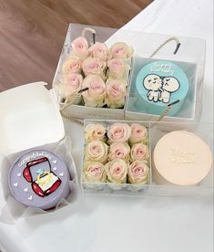 two boxes of cake and some pink roses on a white table with a hello kitty box