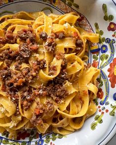 a plate full of pasta with meat and sauce