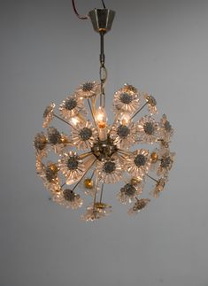 a chandelier hanging from the ceiling with flowers on it's glass petals